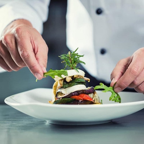 Chefs hands finishing plate for service Chefs hands finishing plate for service