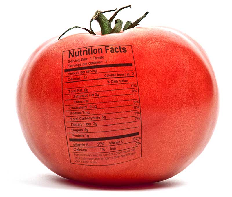 A red tomato with a nutrition facts label printed on its surface.