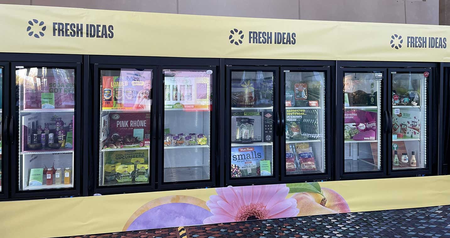 Row of refrigerated display cases with food and beverages beneath a yellow "FRESH IDEAS" banner.